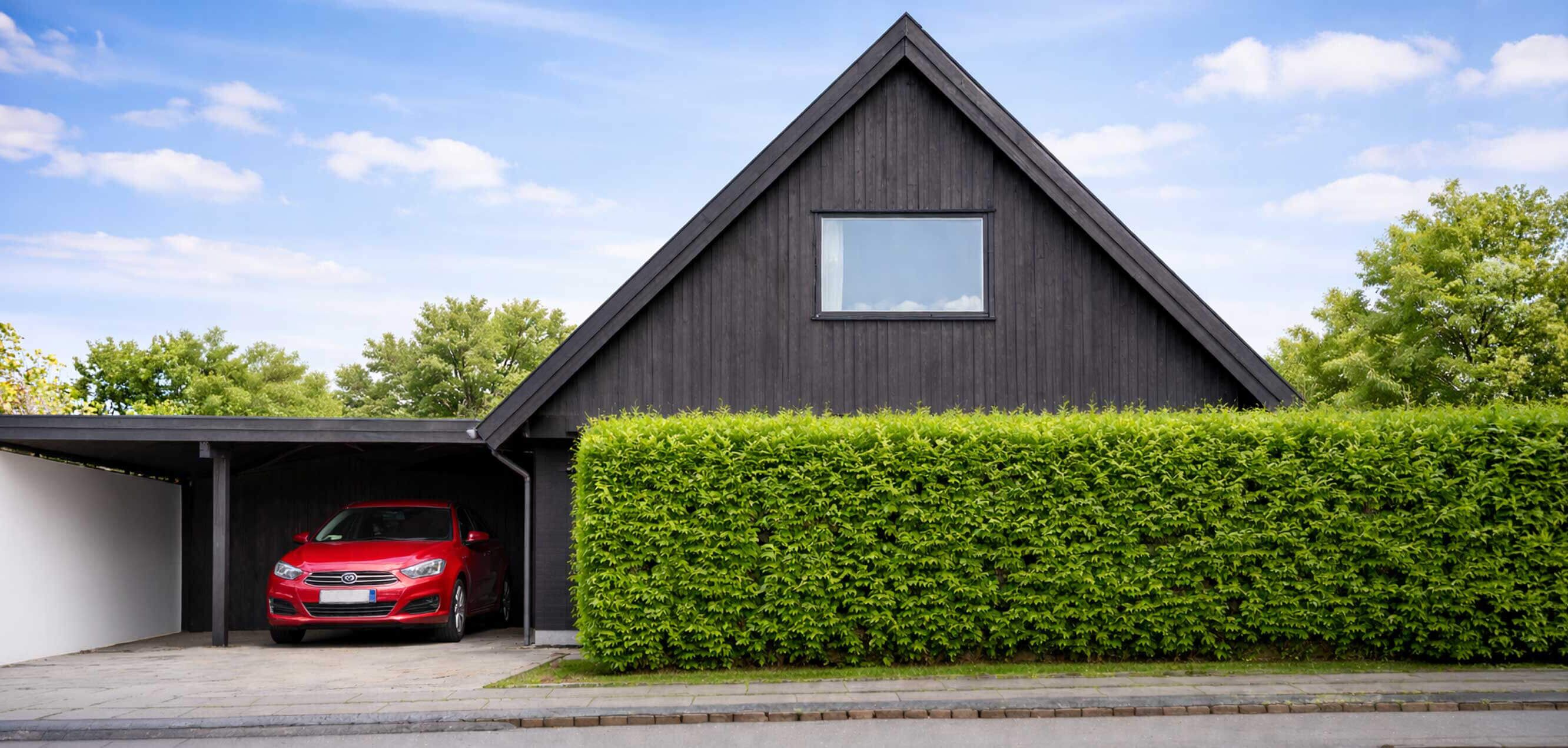 Einfamilienhaus mit Carport und Garten, Symbolbild für Wohngebäude im Kontext von Raumluftuntersuchungen.