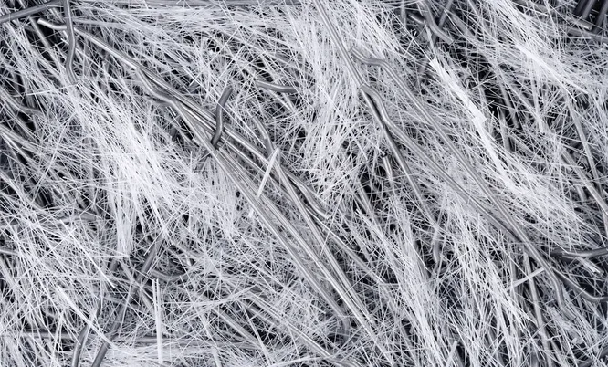 Nahaufnahme verschiedener mineralischer und faserförmiger Materialien als Symbol für die Untersuchung weiterer Gebäudeschadstoffe.