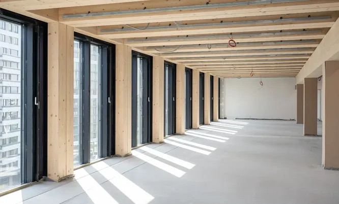 Moderner Innenausbau mit sichtbarer Holzkonstruktion und großen Fensterflächen als Beispiel für nachhaltiges Bauen und Gebäudezertifizierung.